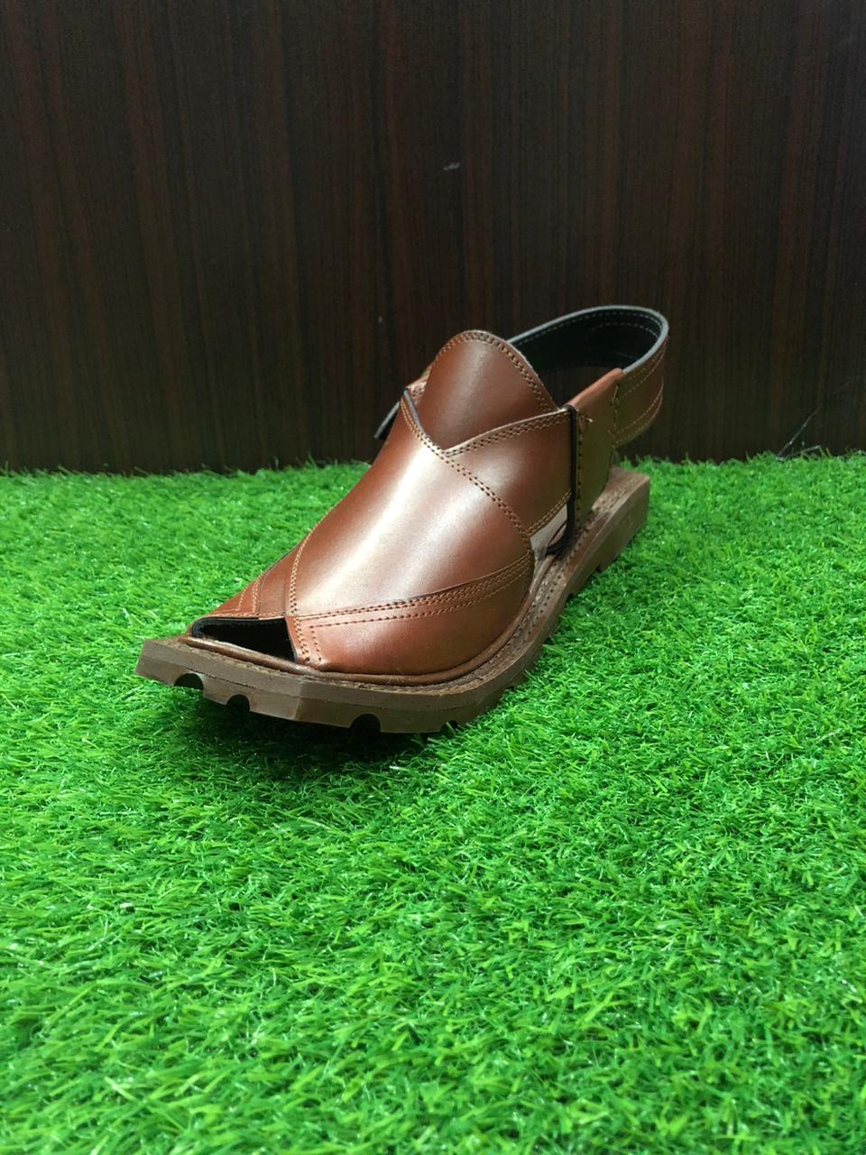 "A pair of classic brown leather Peshawari Chappals, designed with intricate hand-stitched patterns and a traditional open-toe style, popular in Pakistani culture."